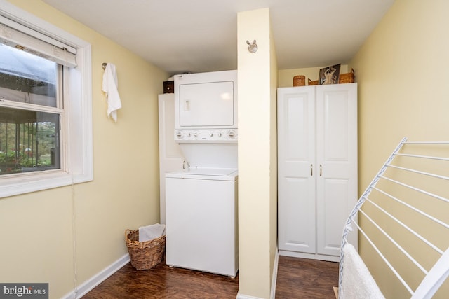 washroom with stacked washer / dryer and dark wood-type flooring