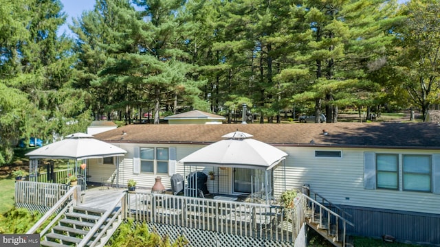 rear view of house featuring a wooden deck