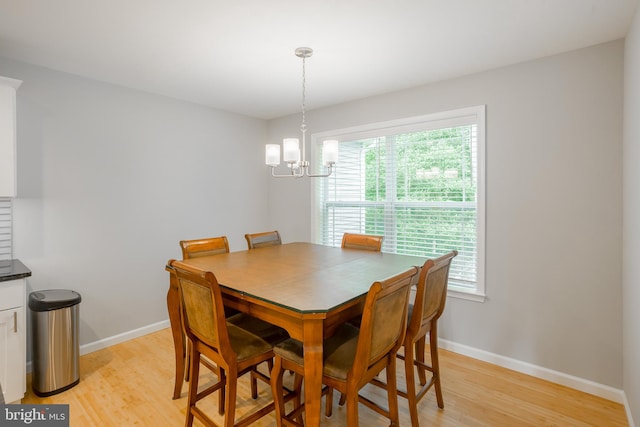 dining space featuring a notable chandelier and light hardwood / wood-style floors