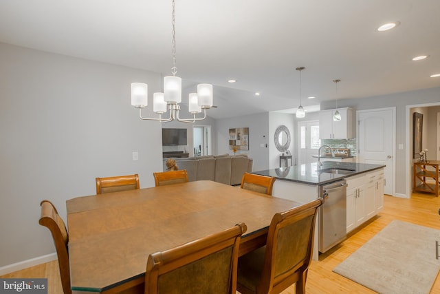 dining space featuring a notable chandelier, light hardwood / wood-style floors, and sink