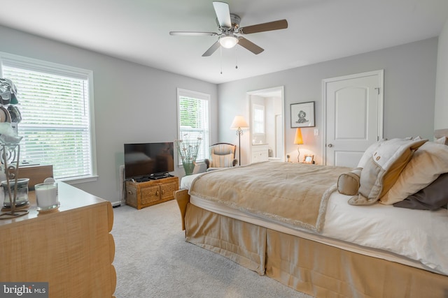 carpeted bedroom featuring multiple windows and ceiling fan