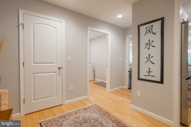 foyer with hardwood / wood-style flooring and washer / dryer