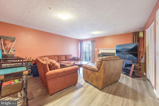 living room featuring a textured ceiling and light wood-type flooring