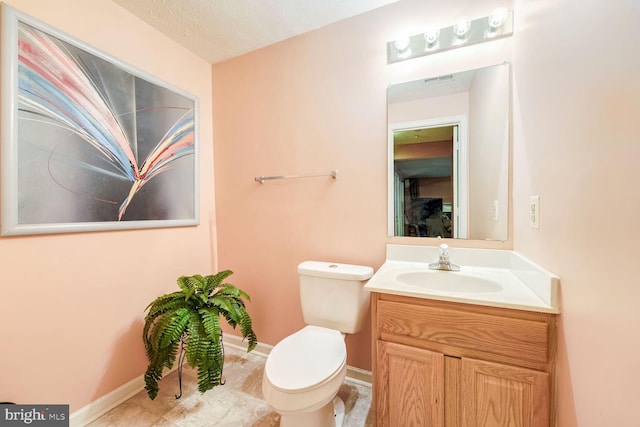 bathroom with vanity, a textured ceiling, toilet, and tile patterned floors