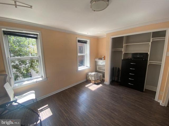 unfurnished bedroom with crown molding, dark hardwood / wood-style floors, and a closet