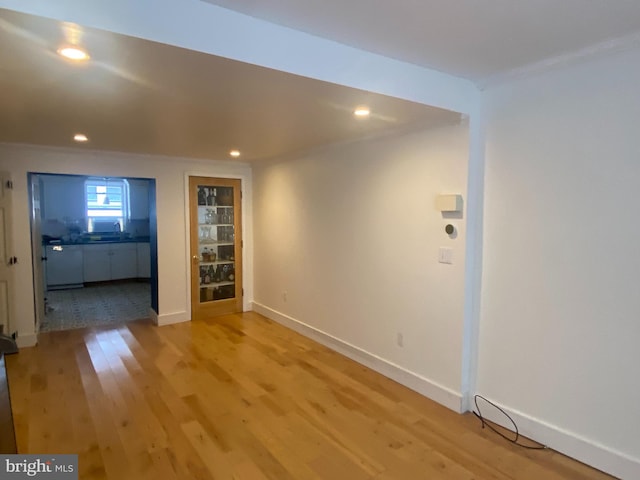 interior space with ornamental molding, light hardwood / wood-style floors, and sink