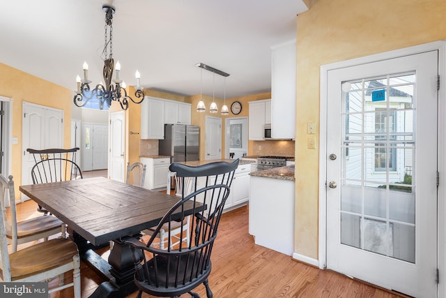 dining room featuring a notable chandelier and light wood-type flooring