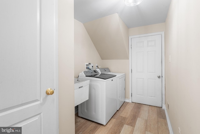 laundry room featuring separate washer and dryer and light hardwood / wood-style flooring