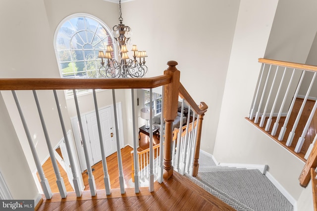 stairs featuring a notable chandelier and hardwood / wood-style floors