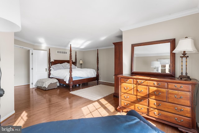 bedroom with wood-type flooring and ornamental molding