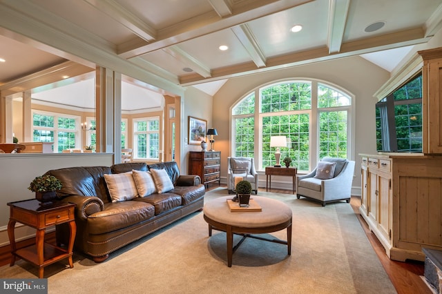 living room featuring beamed ceiling, a healthy amount of sunlight, a chandelier, and light hardwood / wood-style floors