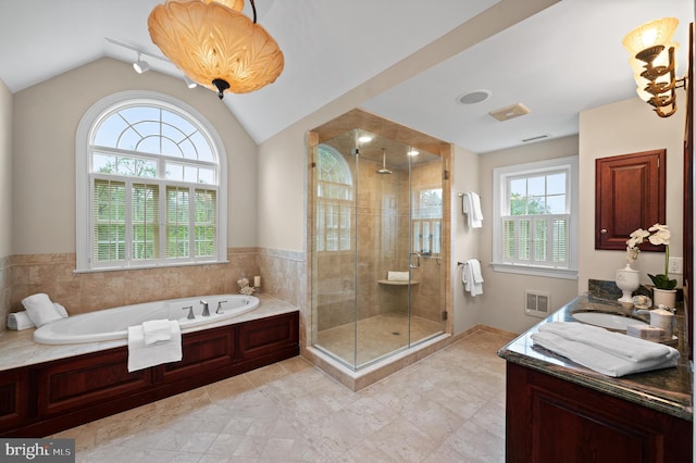 bathroom featuring shower with separate bathtub, vaulted ceiling, and a wealth of natural light