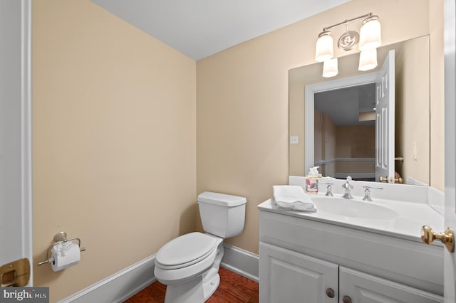 bathroom featuring vanity, hardwood / wood-style floors, and toilet