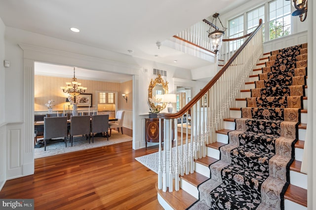 stairway featuring hardwood / wood-style flooring and a chandelier