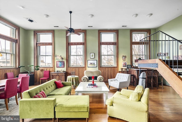 living room featuring ceiling fan, plenty of natural light, and dark wood-type flooring