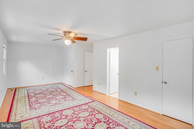 empty room with ceiling fan and light hardwood / wood-style flooring