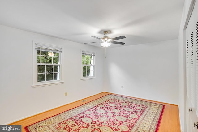 unfurnished room with ceiling fan and hardwood / wood-style flooring