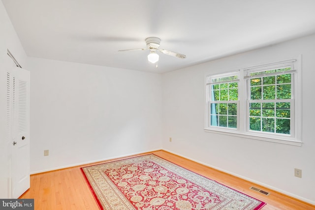 empty room with wood-type flooring and ceiling fan