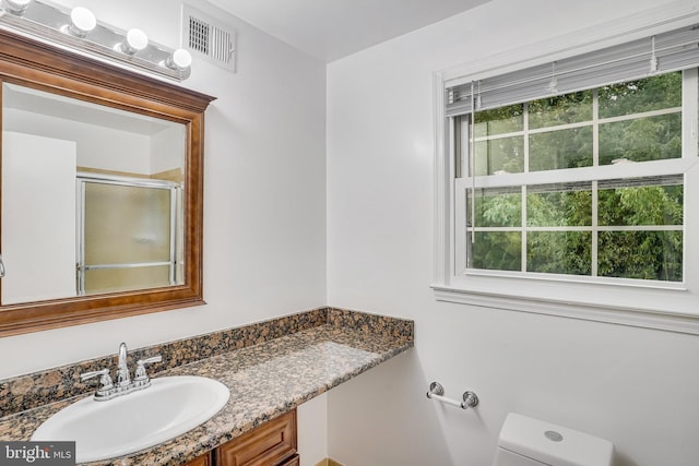 bathroom with vanity, toilet, and an enclosed shower