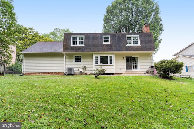 rear view of property featuring central AC unit and a yard