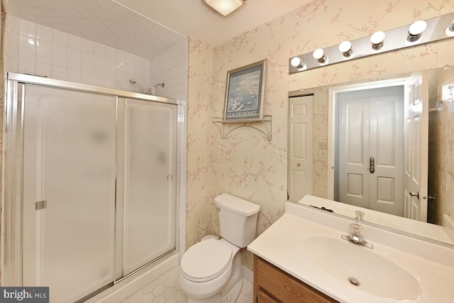 bathroom featuring a stall shower, vanity, toilet, and wallpapered walls