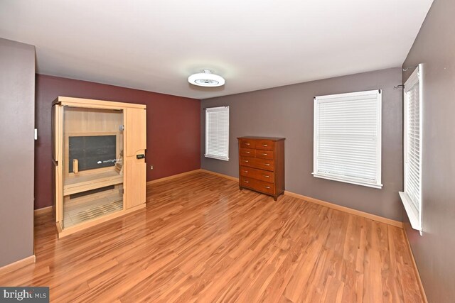 unfurnished bedroom with light wood-style flooring and baseboards