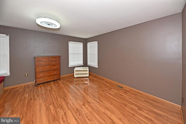 interior space with light wood-type flooring, visible vents, and baseboards