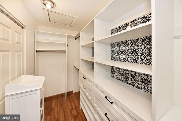 spacious closet featuring attic access and wood finished floors