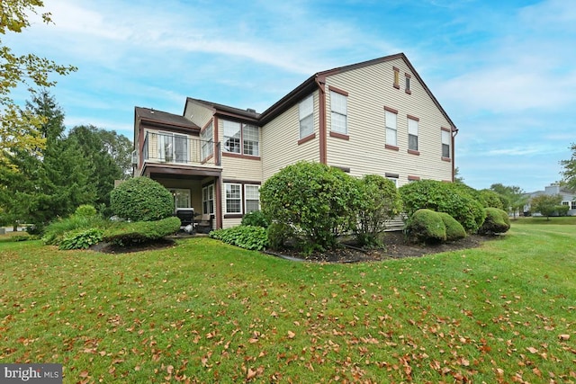 view of property exterior with a yard and a balcony