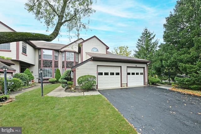 multi unit property featuring aphalt driveway, a front lawn, and an attached garage