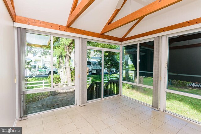 unfurnished sunroom with vaulted ceiling with beams