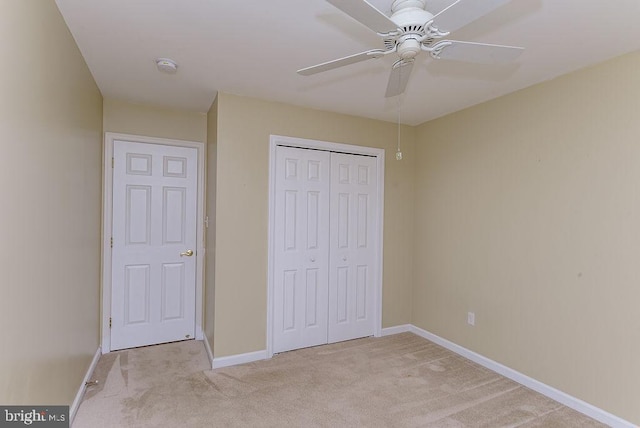 unfurnished bedroom featuring light carpet, a closet, and ceiling fan