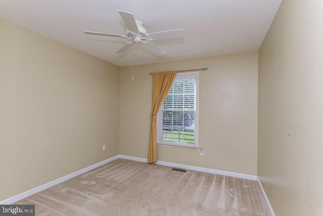 empty room featuring ceiling fan and light colored carpet