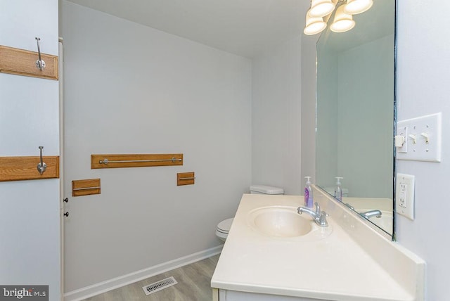 bathroom featuring wood-type flooring, vanity, and toilet