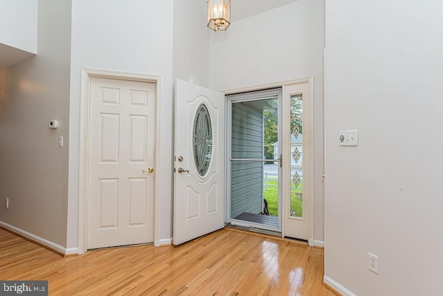 entryway with light wood-type flooring and a high ceiling