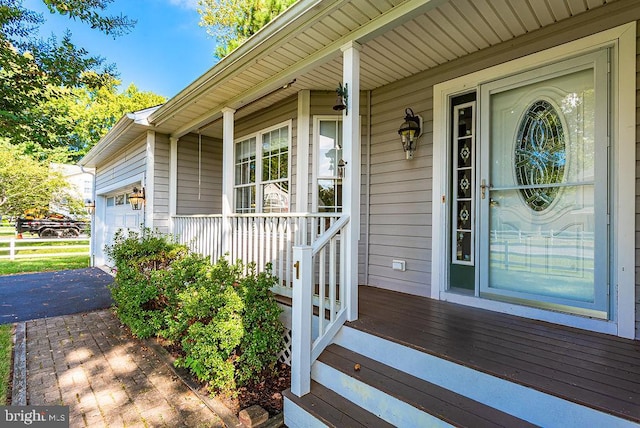 entrance to property featuring covered porch and a garage