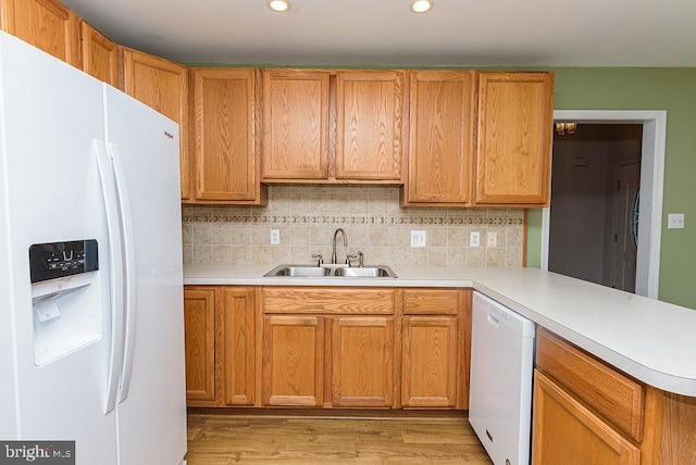 kitchen featuring decorative backsplash, light wood-type flooring, white appliances, and sink