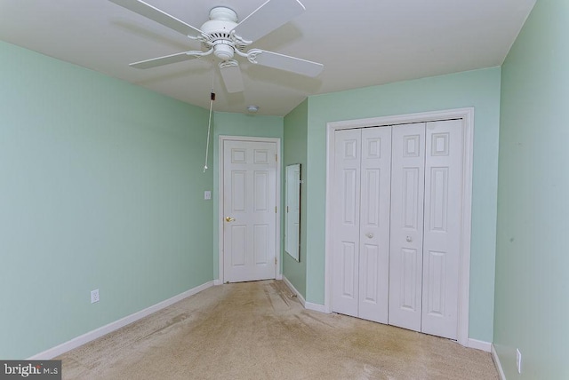 unfurnished bedroom featuring light carpet, ceiling fan, and a closet