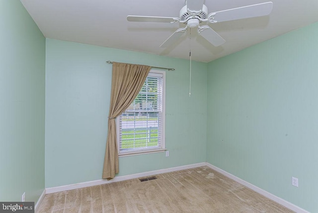 carpeted spare room featuring ceiling fan