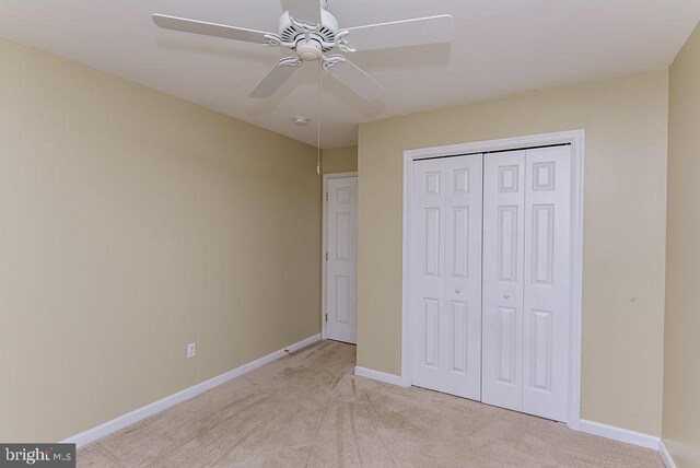 unfurnished bedroom with light carpet, a closet, and ceiling fan