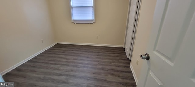 unfurnished bedroom with dark hardwood / wood-style flooring