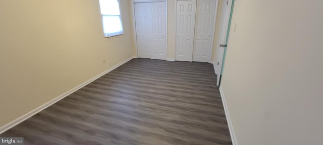 unfurnished bedroom with dark wood-type flooring