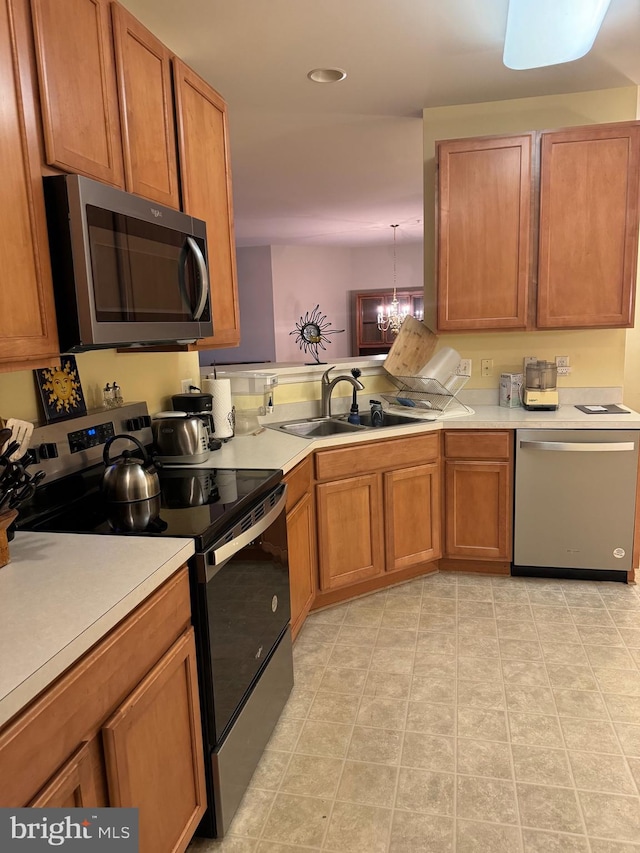 kitchen with a chandelier, sink, and stainless steel appliances