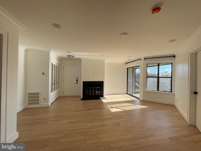 unfurnished living room with light wood-type flooring and ornamental molding