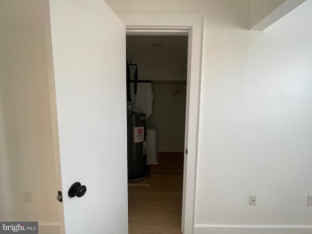 hallway featuring hardwood / wood-style floors and electric water heater