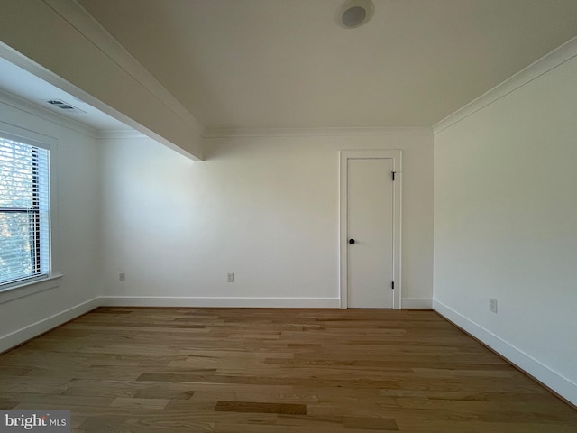 spare room featuring hardwood / wood-style floors and crown molding