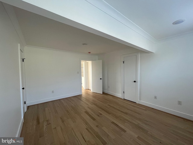 spare room featuring hardwood / wood-style flooring and crown molding