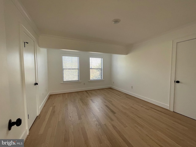 spare room with crown molding and light hardwood / wood-style flooring