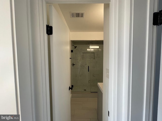 bathroom featuring tile patterned floors, a shower with door, and vanity