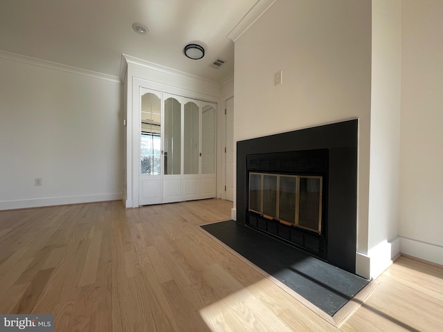 unfurnished living room with crown molding and light hardwood / wood-style flooring